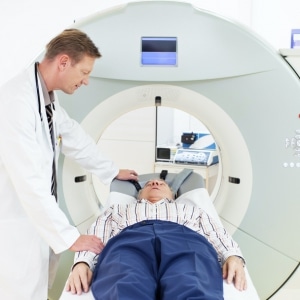 white doctor with old man in mri machine