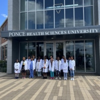 Mini Medical Students in their white coats outside PHSU St. Louis.