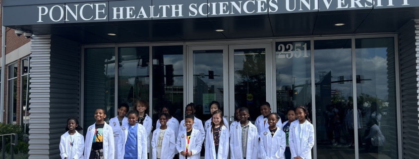 Mini Medical Students in their white coats outside PHSU St. Louis.