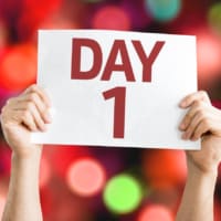 Image of someone holding a sign that says "Day 1"