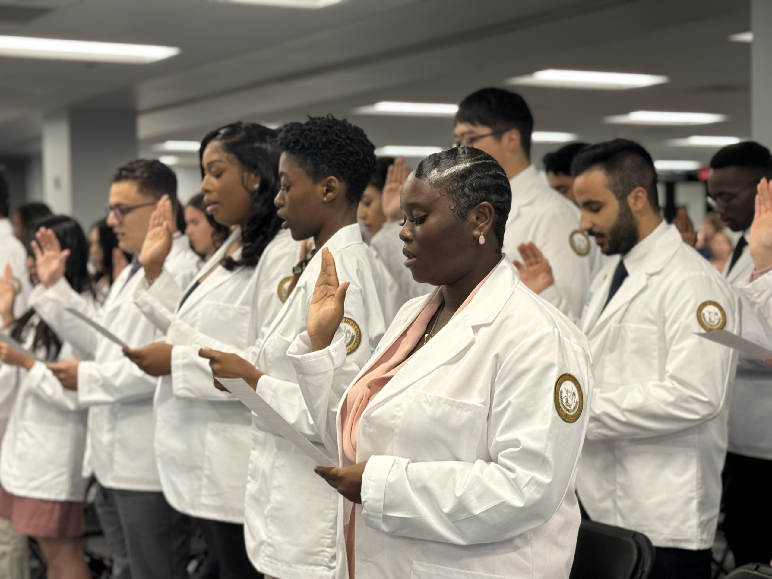 Diverse medical students of Ponce Health Sciences University PHSU recite hippocratic oath at white coat ceremony