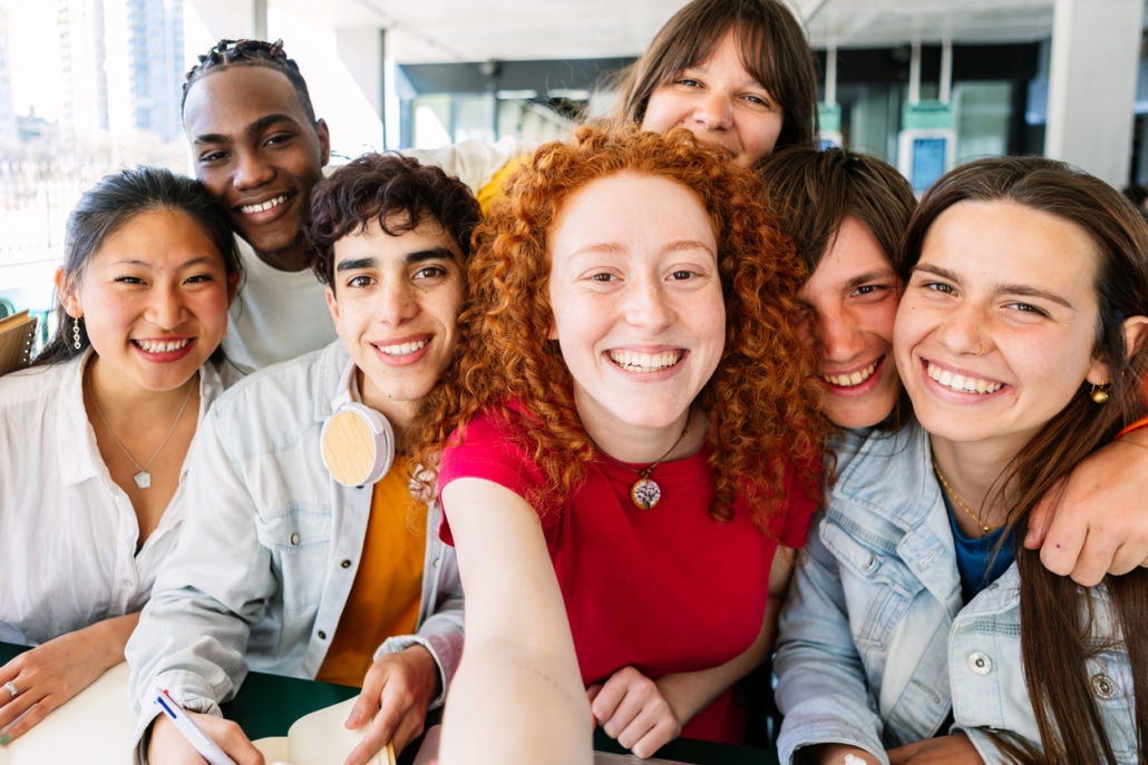 Multiracial group of young student people taking selfie while studying together